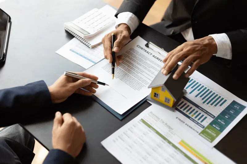Clients signing real estate documents with guidance from a Realtor in Aurora, Colorado.