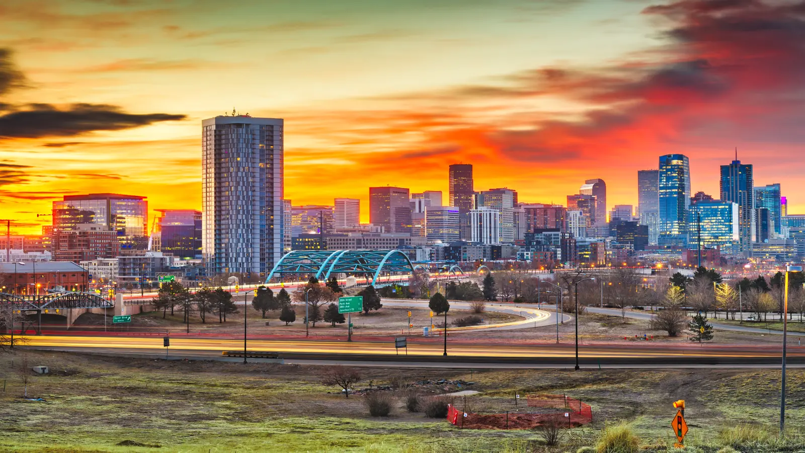 Denver skyline at sunset with mountains, representing homes for sale in Denver and the surrounding metro area.