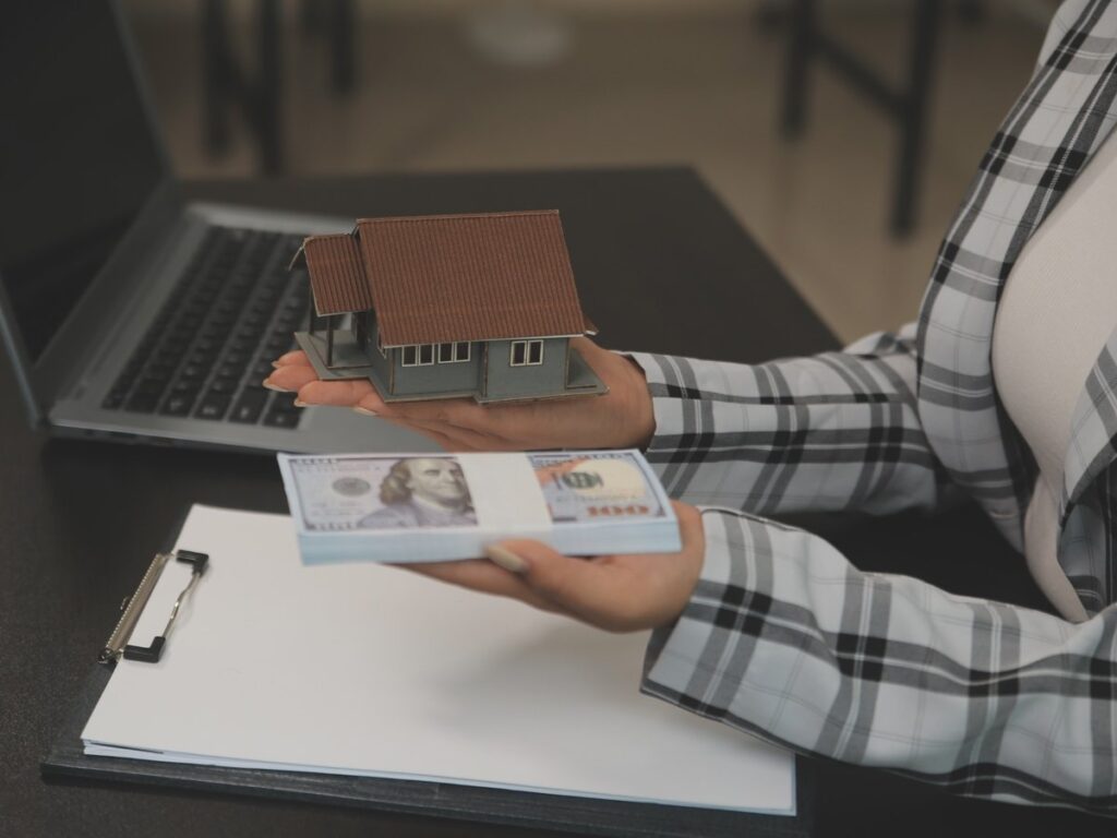 woman holding a stack of money in her right hand with additional bills on the left — visual for guides about estimating home value in Denver, CO.