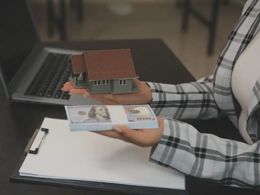 woman holding a stack of money in her right hand with additional bills on the left — visual for guides about estimating home value in Denver, CO.