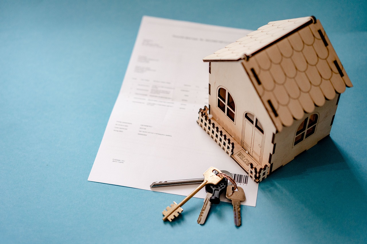 Small house model and keys on paperwork — realtor in Aurora ready for a home closing or buyer consultation.